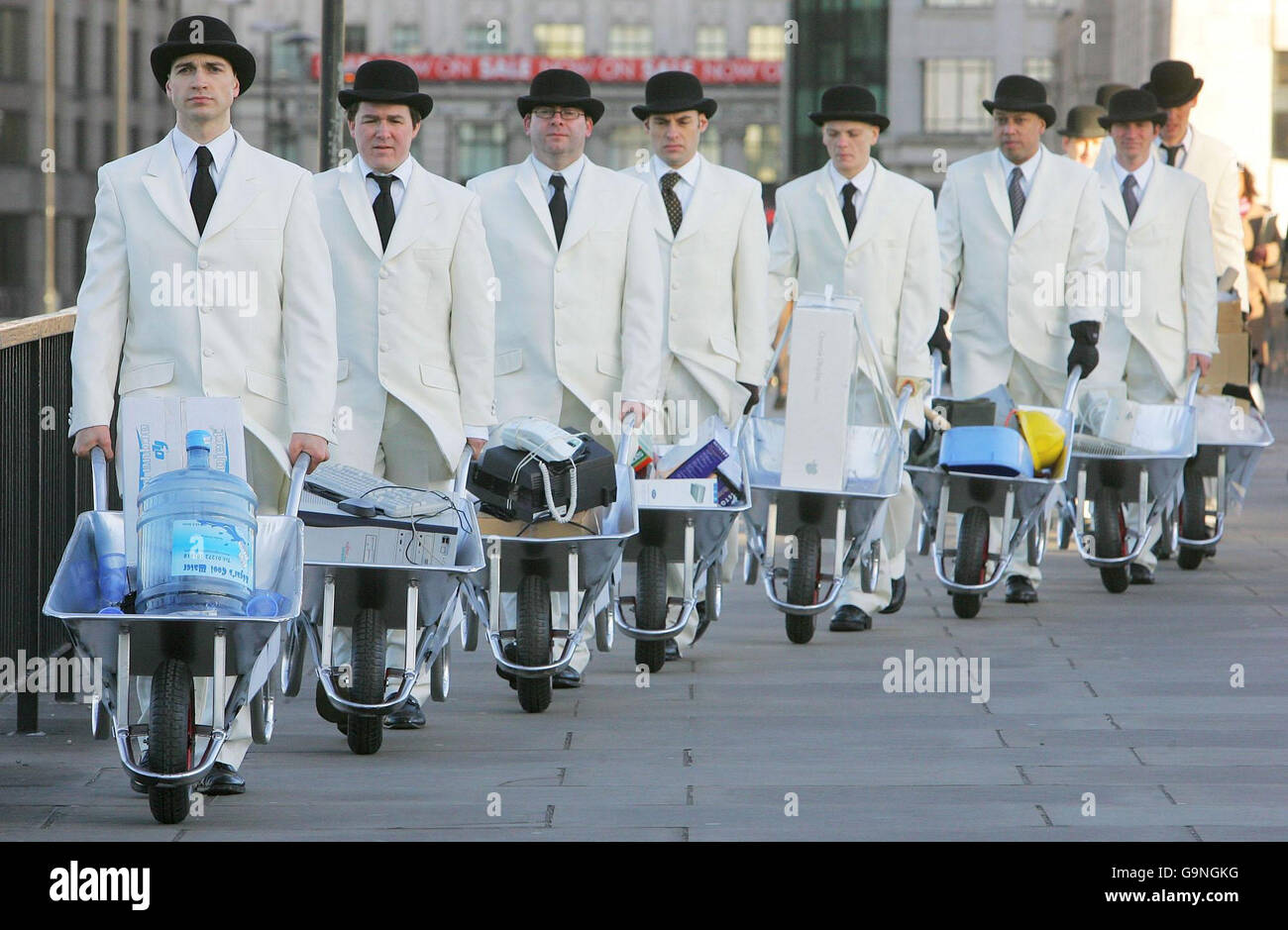 Dix hommes, en brouettes blanches, poussent des brouettes pleines de déchets de bureau sur le London Bridge ce matin pour souligner l'impact environnemental élevé des déchets d'entreprise. Banque D'Images