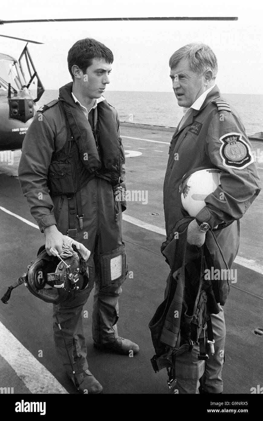 Le Capt Lyn Middleton (à droite), responsable du HMS Hermes, rencontre son fils, le sous-Lt Ray Middleton, 21 ans, à bord du navire le lundi de Pâques. Le capitaine Middleton a traversé la plate-forme de vol du porte-avions pour saluer Ray qui venait de faire voler son hélicoptère Lynx depuis un navire de guerre voisin pour faire un dépôt d'approvisionnement. Plus tard, Ray a fait voler son père au navire Ray sert, où le Capt Middleton a discuté de la voie à suivre. Banque D'Images