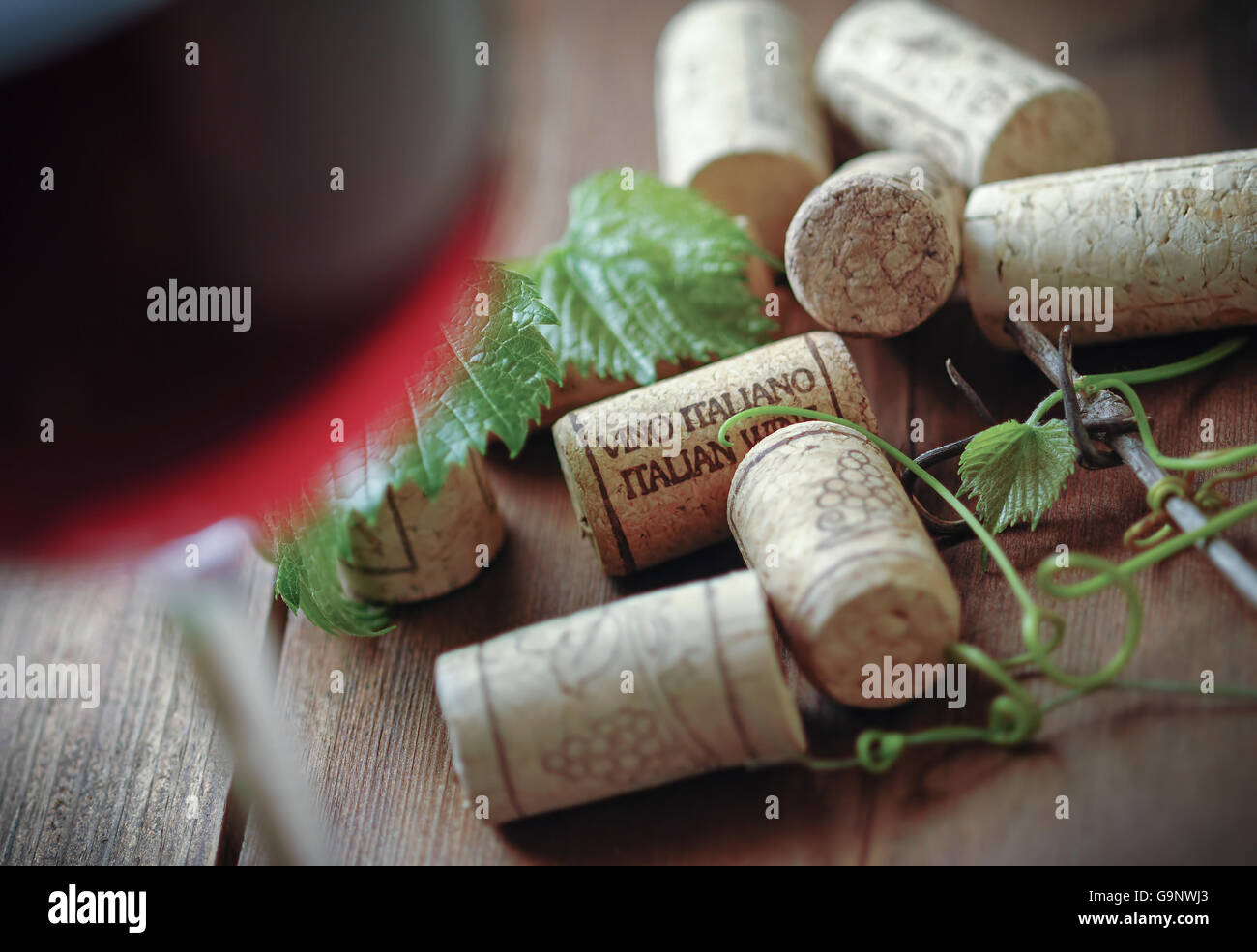 Verre de vin rouge italien avec des bouchons sur table en bois Banque D'Images