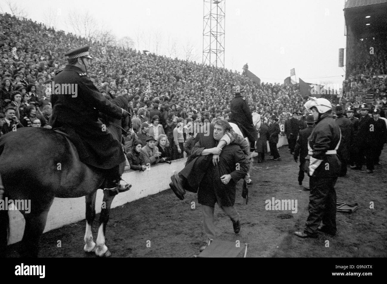 Un ventilateur blessé est transporté alors que la police essaie pour contrôler les problèmes de foule Banque D'Images