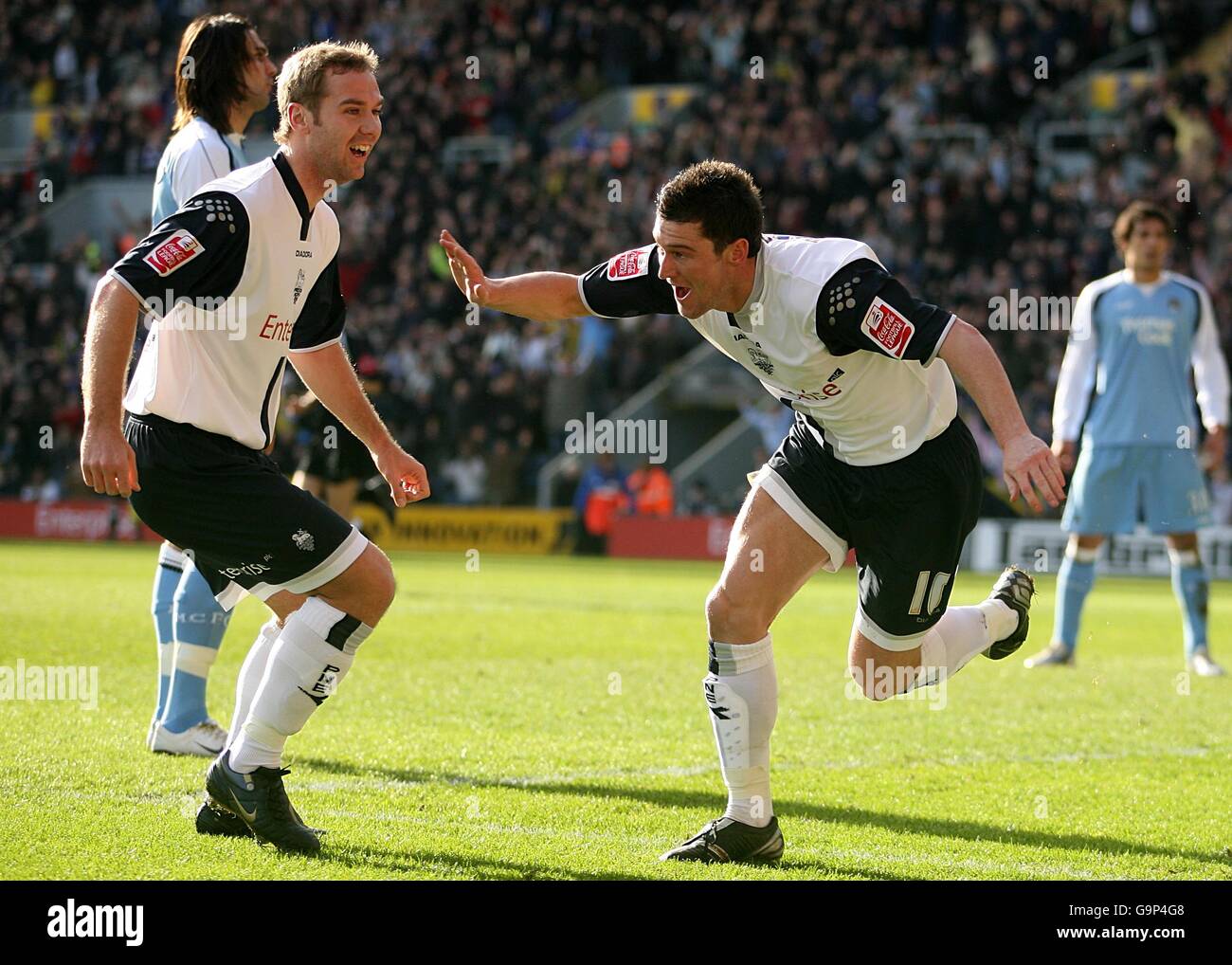 David Nugent (à droite du centre) de Preston North ends célèbre le premier but du match, avec Liam Chilvers (à gauche du centre), le coéquipier, tandis que les joueurs de Manchester City sont sur le point de tomber Banque D'Images