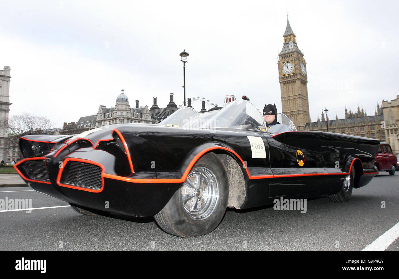 Un homme habillé comme Batman conduit un 'Batmobile' original de la série télévisée des années 1960 autour de la place du Parlement à Londres. Banque D'Images