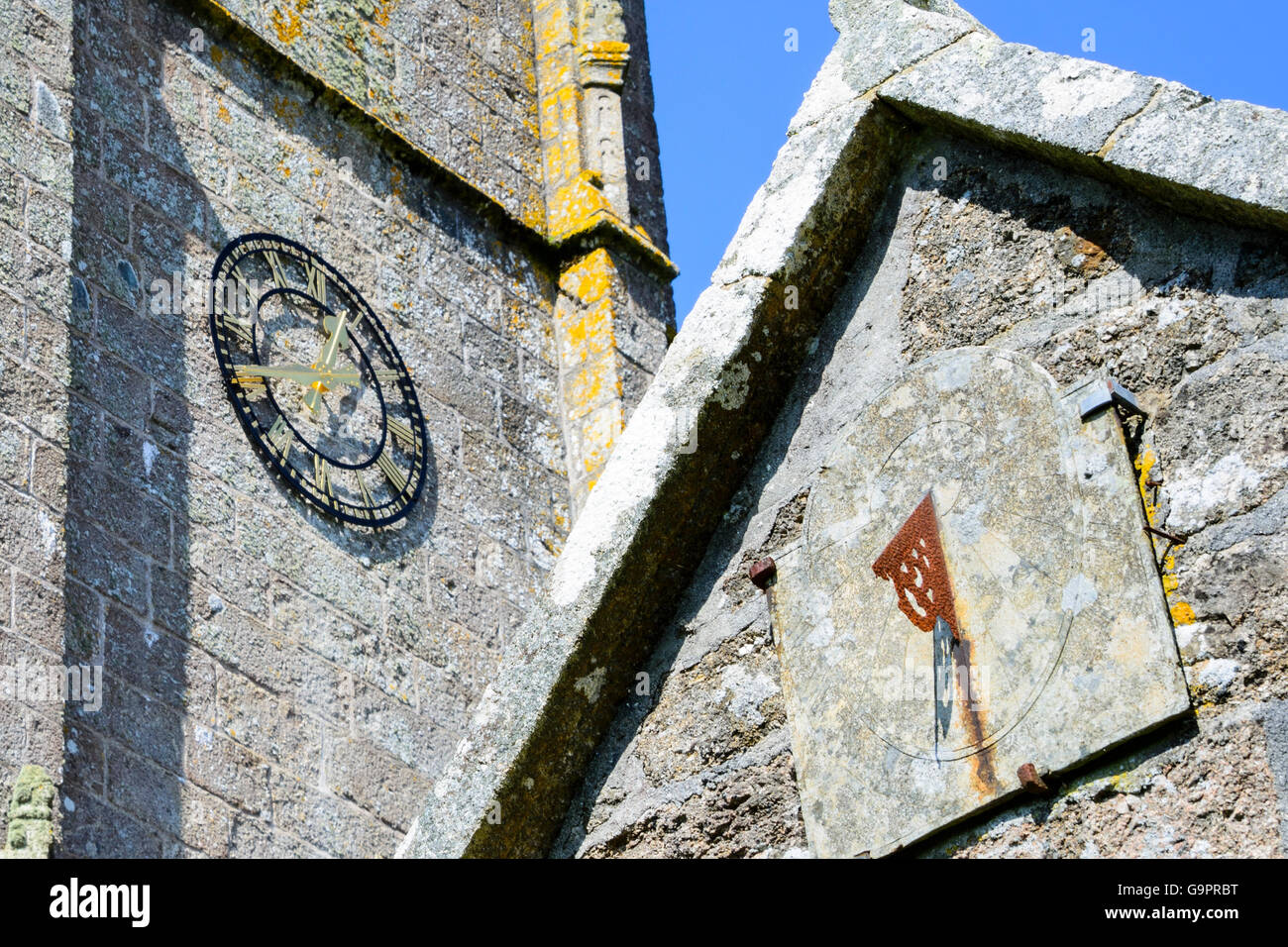 Ancienne église cadran solaire et l'horloge de l'église moderne en juxtaposition. Banque D'Images