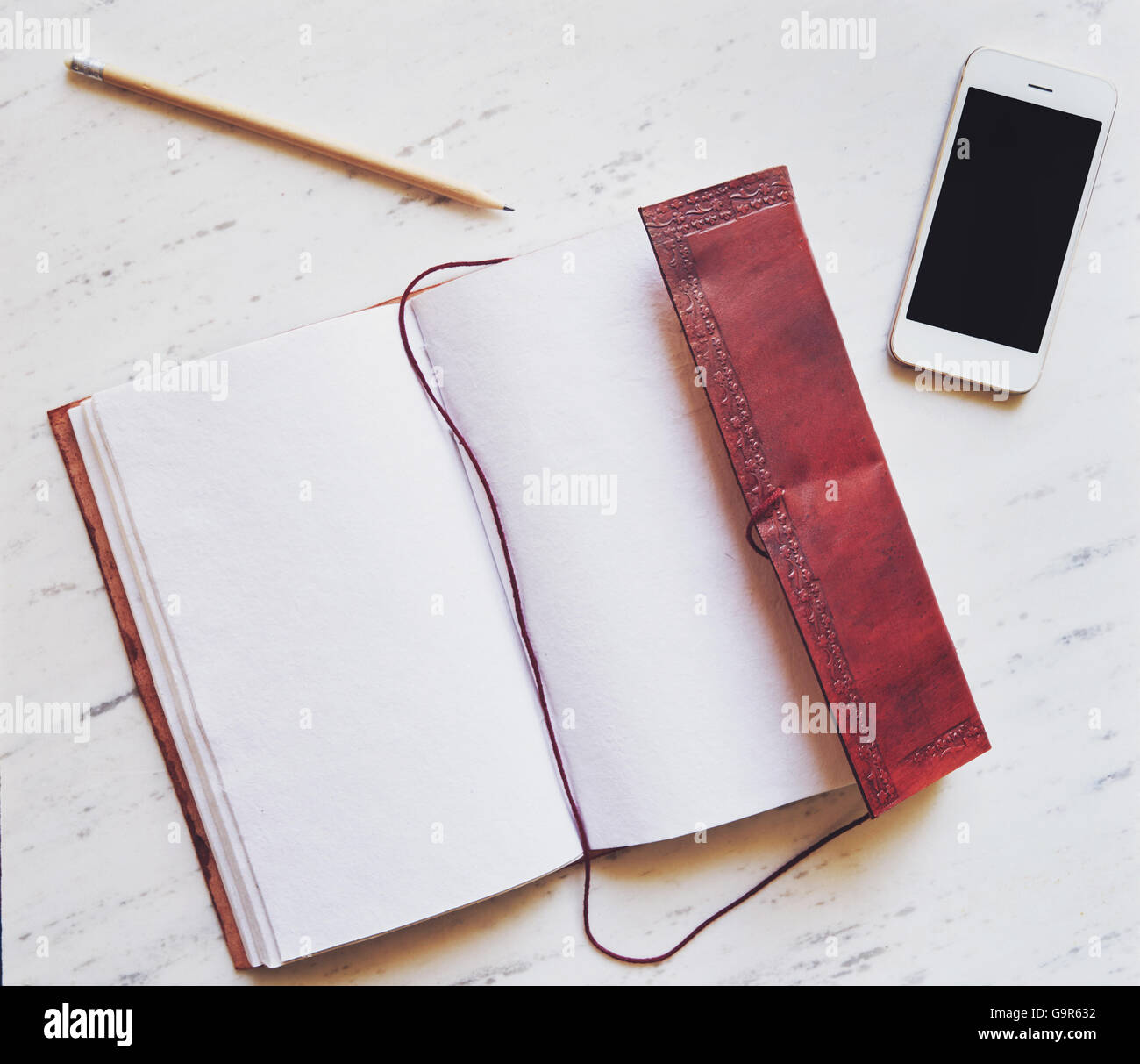 Vue de dessus, le bloc-notes et crayon sur smartphone en arrière-plan Banque D'Images