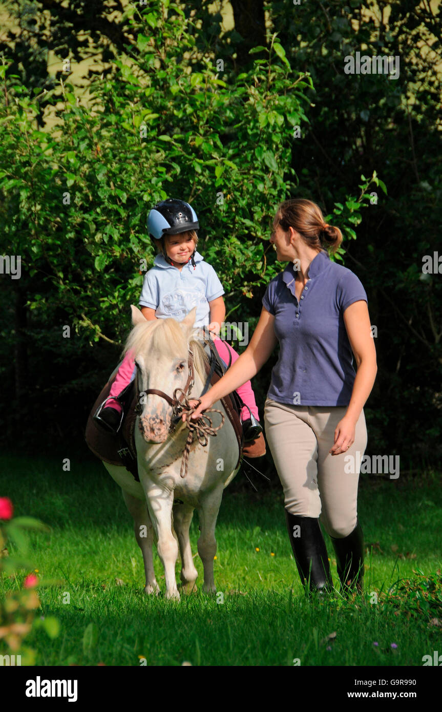 Femme fille leader sur poney Shetland / marche, leadline Banque D'Images