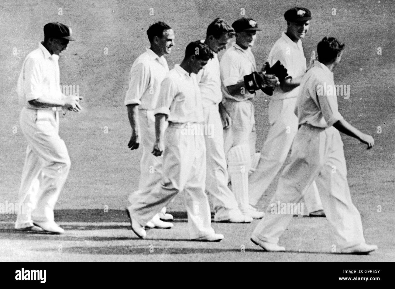 Ray Lindwall (r), un australien, part avec ses coéquipiers après se réclamant de son 100e test de cricket Banque D'Images