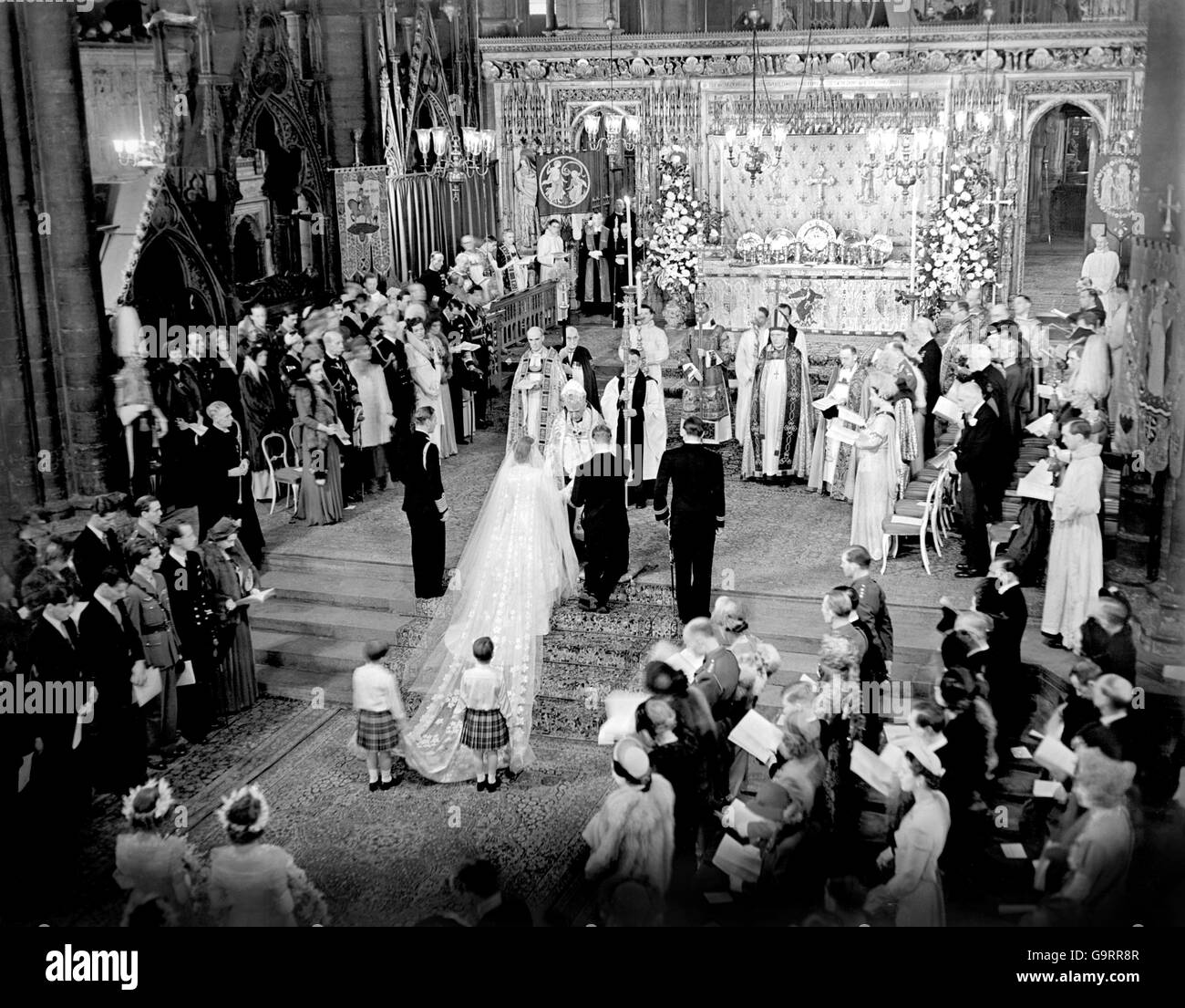 La scène à l'autel marche pendant la cérémonie royale de mariage à l'abbaye de Westminster. H.M le Roi se trouve à gauche de la mariée; à droite de l'époux se trouve le groomman, les marques de Milford Haven. Le train de la mariée est tenu par deux pages T.R.H Prince William de Gloucester et le Prince Michael de Kent. Banque D'Images