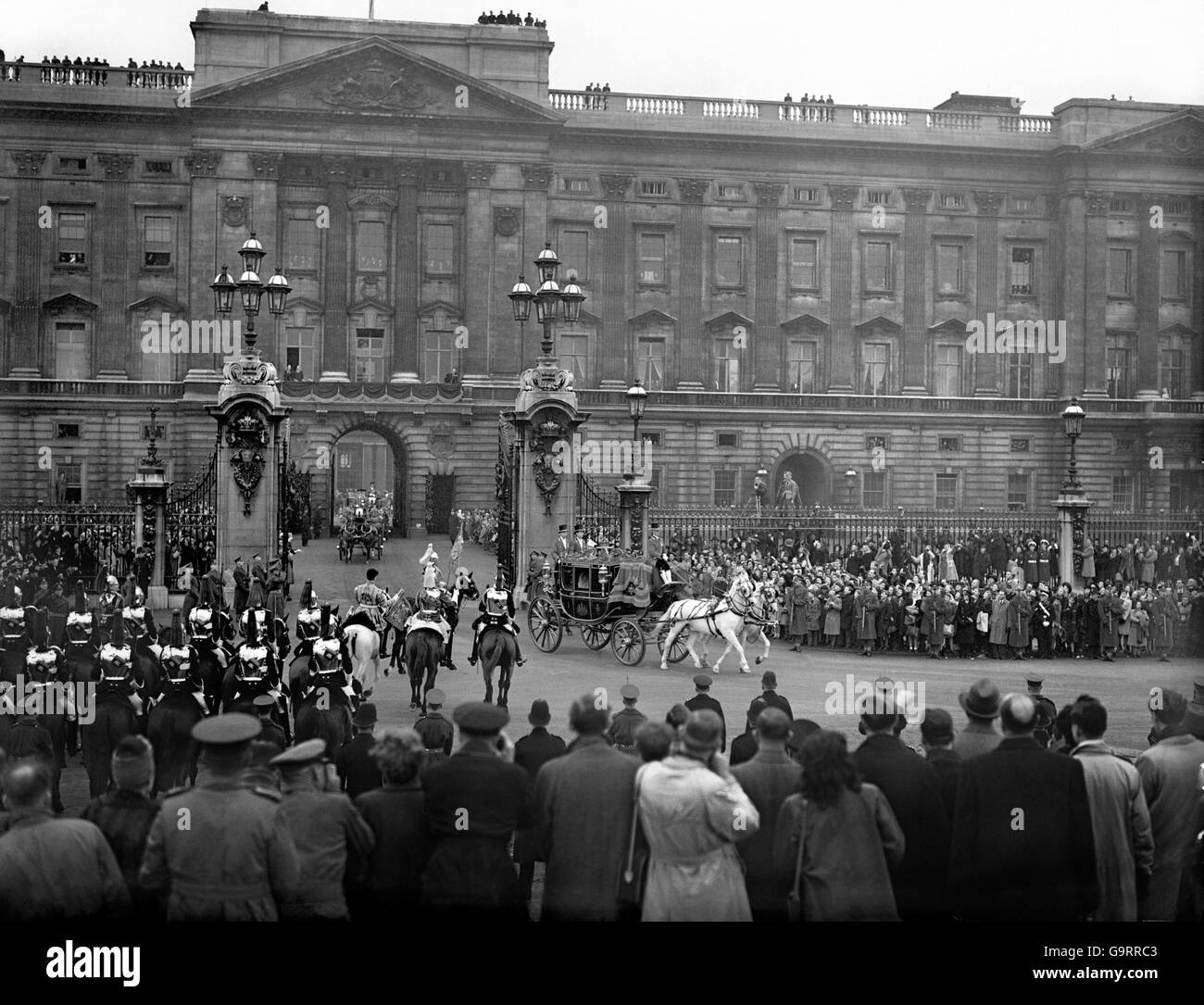 Les Londoniens se dressent autour des portes de Buckingham Palace pour un aperçu de la princesse Elizabeth et de Lieut Mountbatten Banque D'Images
