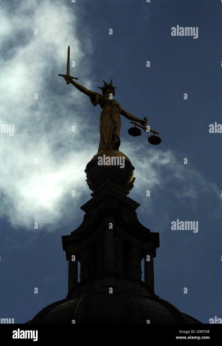 Vue, silhouetée contre le ciel, de la statue en or de la figure de justice, tenant des écailles et une épée, au-dessus de la Cour pénale centrale, également appelée Old Bailey, dans le centre de Londres. Banque D'Images