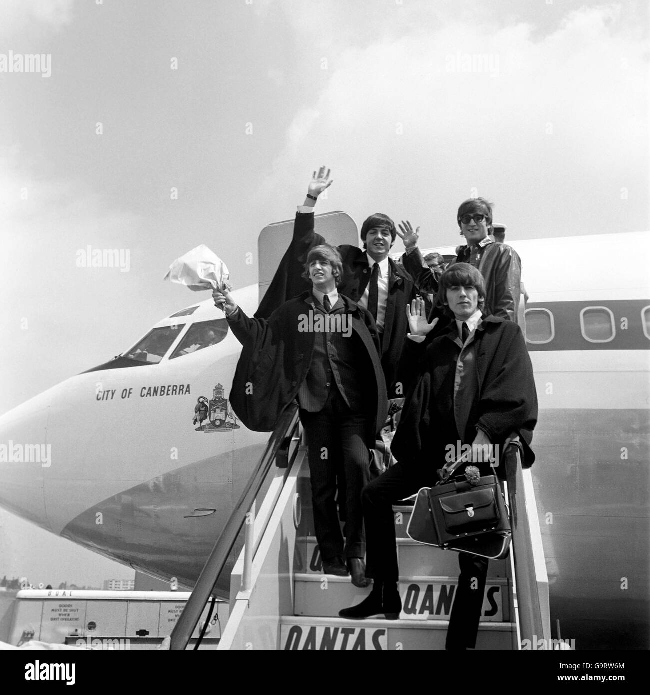 Les Beatles, portant des manteaux de type cape, sur les marches de l'avion à l'arrivée à l'aéroport de Londres de leur visite en Australie. Lors d'une conférence de presse à l'aéroport, Lennon a nié une rumeur selon laquelle il quittait le groupe. Banque D'Images