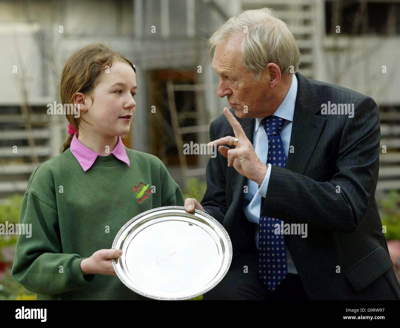 Eilidh Willis, onze ans, d'Oban, reçoit une plaque du Président George Reid après qu'elle soit devenue le millionième visiteur au Parlement écossais à Holyrood, Édimbourg. Banque D'Images