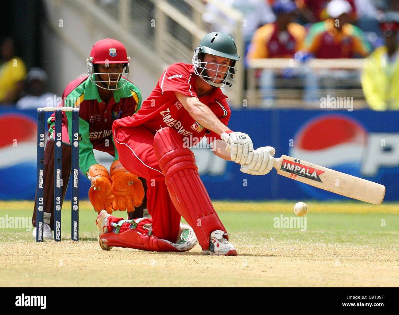 Sean Williams, batteur du Zimbabwe, lance des courses pour son côté, sous la surveillance du gardien de cricket Denesh Ramdin lors du deuxième match du groupe D de la campagne de la coupe du monde de cricket de la CPI à Sabina Park à Kingston, en Jamaïque. Banque D'Images