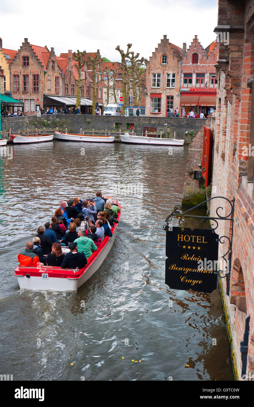 Les touristes profitant d'une excursion en bateau sur les canaux de Bruges en Belgique. Banque D'Images
