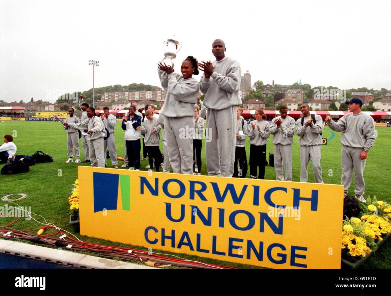 Aux États-Unis, Gail Devers (l) lève le trophée Norwich Union comme ses coéquipiers célèbrent Banque D'Images