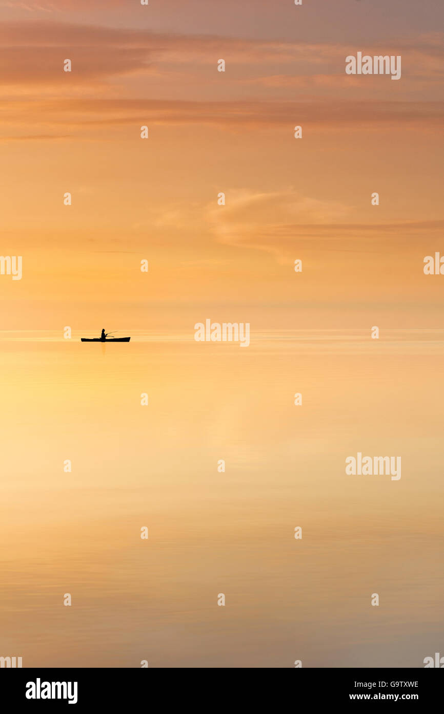 Un pêcheur dans un canot dérive dans les eaux calmes de la baie de Biscayne Banque D'Images Un pêcheur dans un canot dérive dans les eaux calmes de la baie de Biscayne Banque D'Images