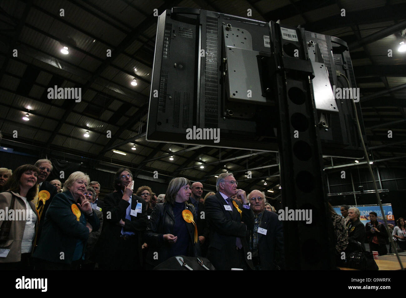 Les membres du parti, dont le député de Malcolm Bruce (main du milieu sur le menton), peuvent voir des écrans de télévision affichant des bulletins de vote qui ont été scannés par les machines automatiques pour le compte de la ville d'Aberdeen et du Shire d'Aberdeen pour les élections parlementaires écossaises à Aberdeen. Banque D'Images