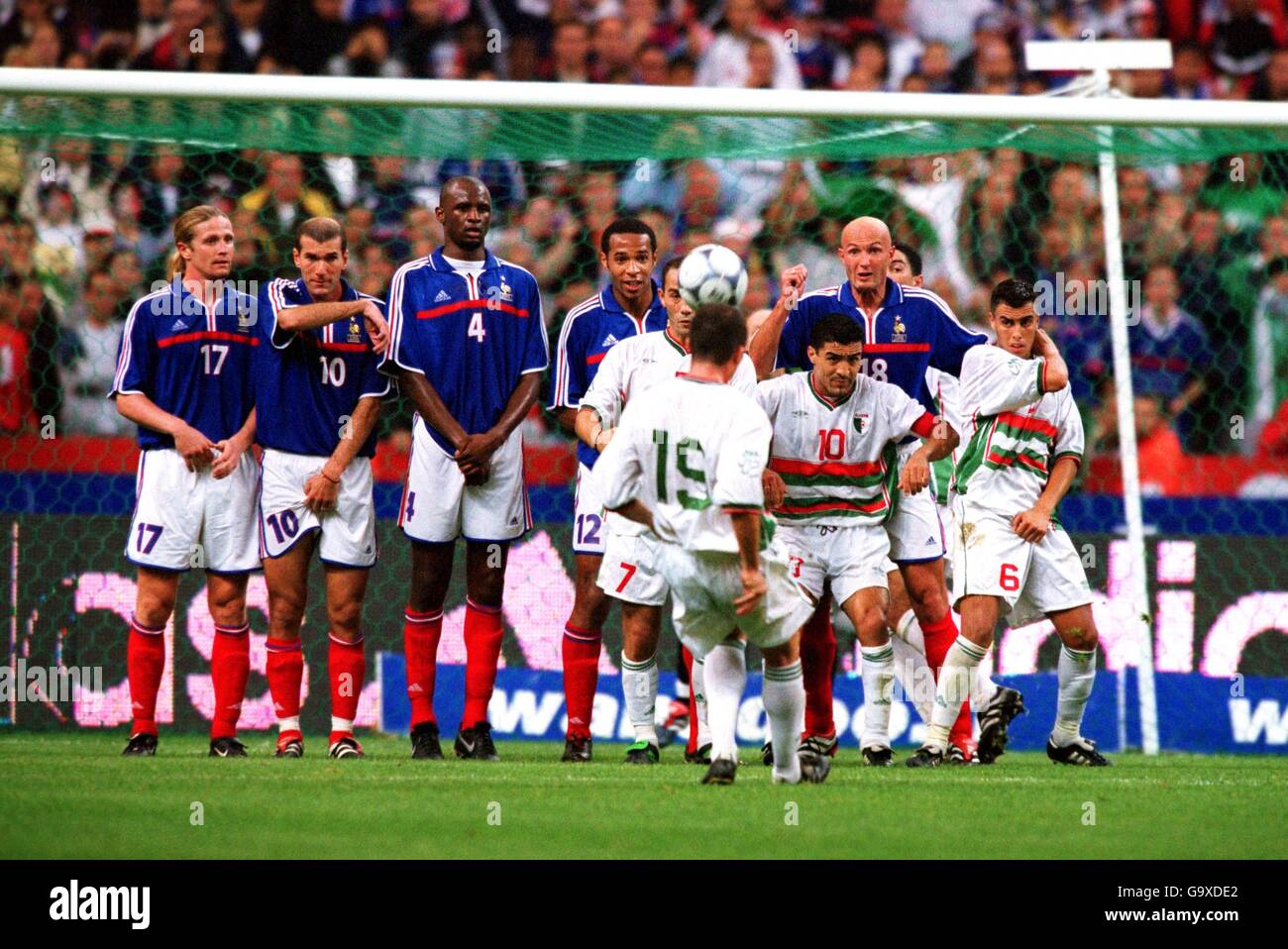 Le Djamel Belmadi (no19), en Algérie, tente de courber un coup de pied libre Sur le mur de France alors que ses coéquipiers font des ravages Banque D'Images