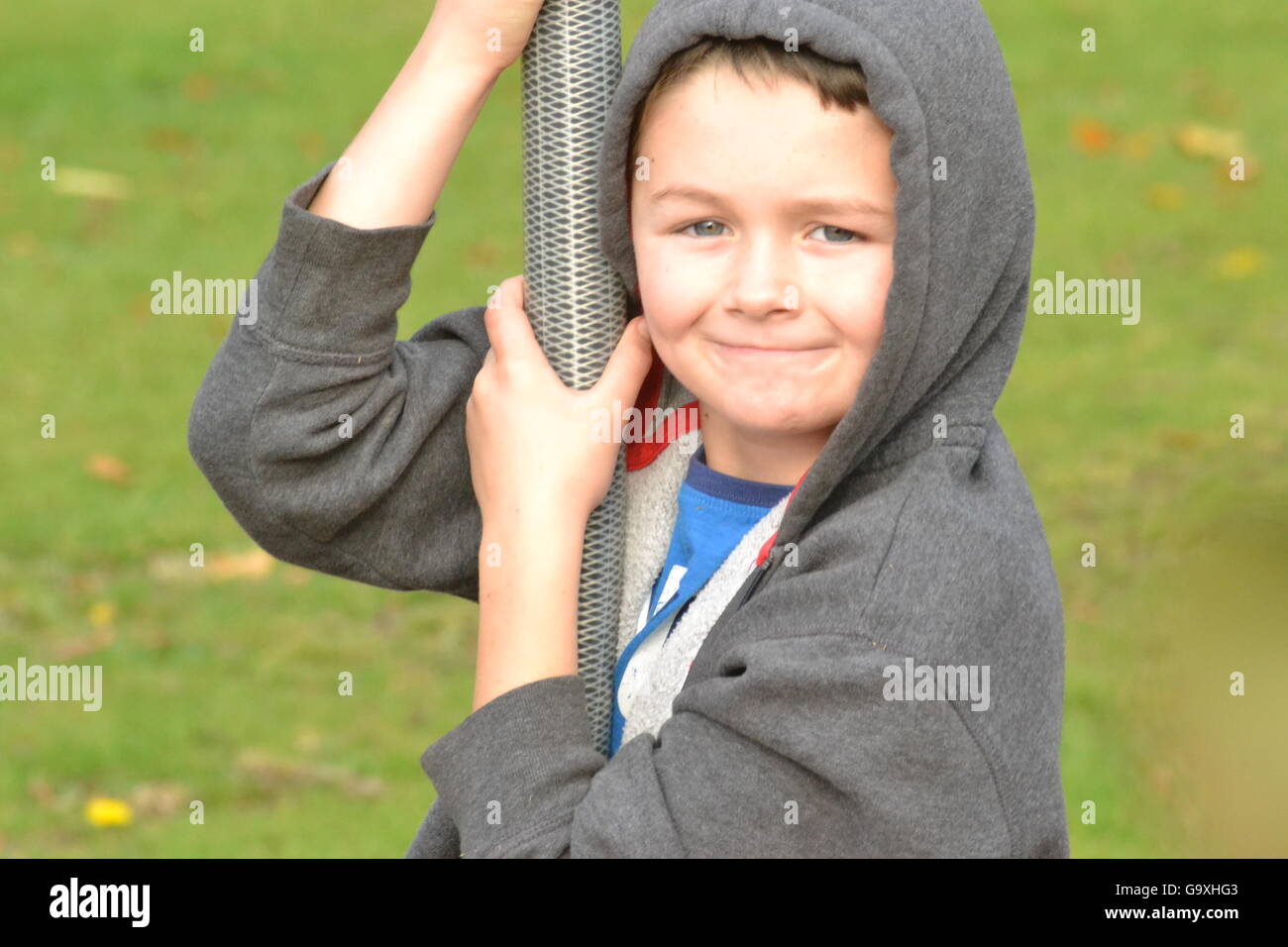 Cute boy flying par sur une balançoire dans le parc smiling Banque D'Images