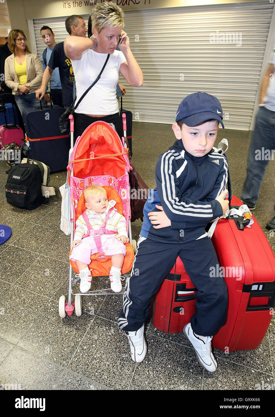 Layla Nugent, sa fille de neuf mois Katie et le fils de sept ans de son partenaire Jordan se préparent à s'enregistrer pour un vol à destination de Charm el-Cheikh à l'aéroport de Newcastle. Banque D'Images