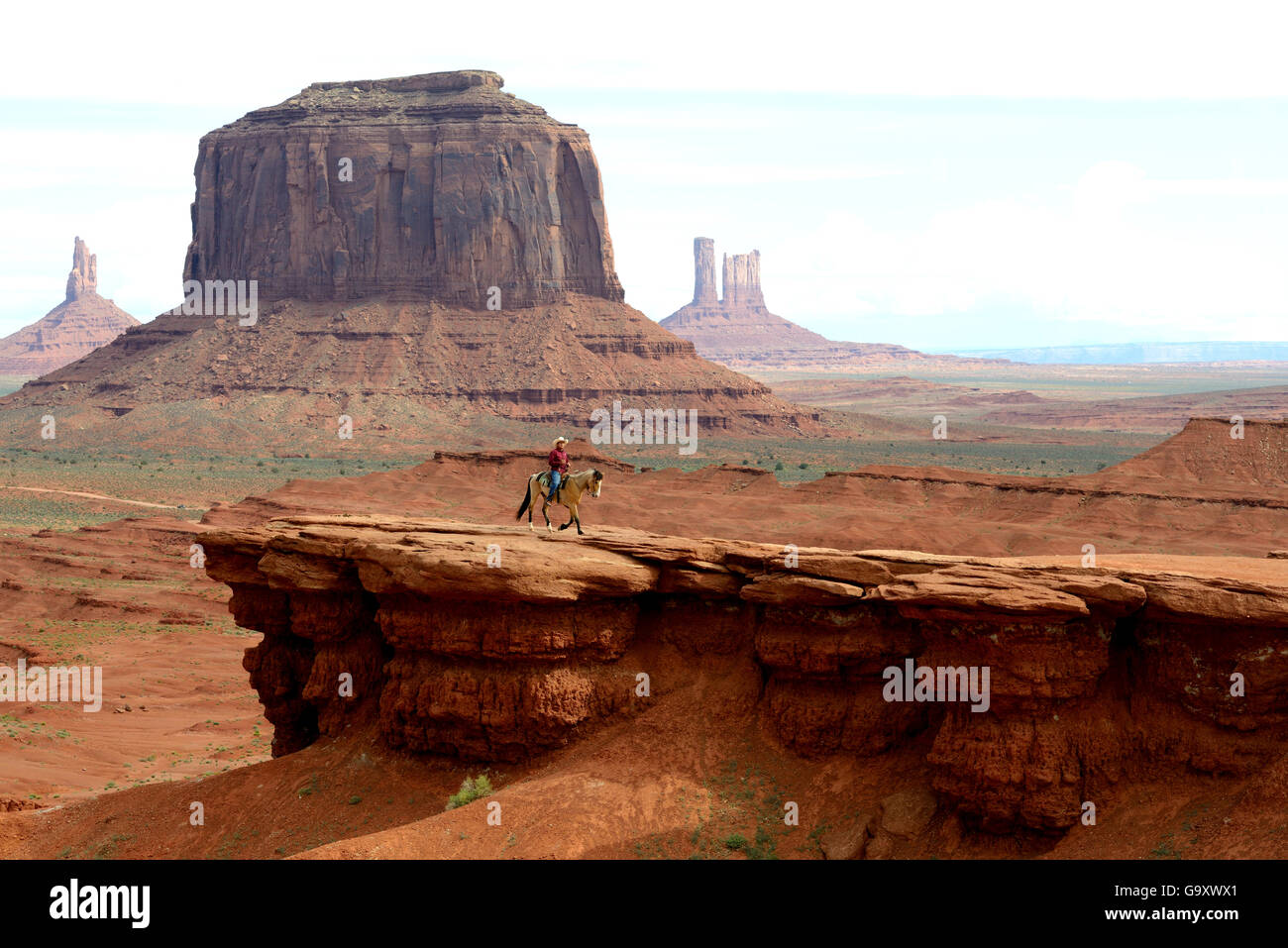 Homme Navajo cheval en face des formations rocheuses de Monument Valley, Utah, USA, mai 2014. Banque D'Images