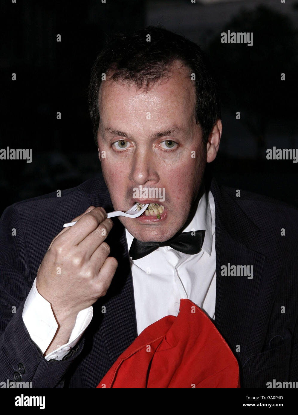 Mark McGowan, activiste des droits des artistes et des animaux, mange un morceau de chien Corgi dans une protestation contre la famille royale et leur traitement des animaux, à l'extérieur de la radio FM Resonance à Denmark Street, dans le centre de Londres. Banque D'Images