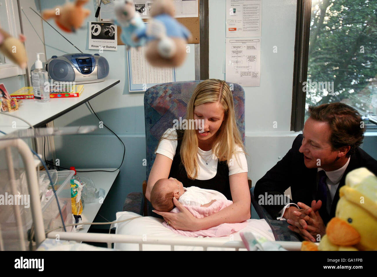 Le chef du Parti conservateur David Cameron, à droite, parle à la nouvelle maman Scarlett O'Riordon avec son bébé Scarlette âgé de 68 jours lors d'une visite à l'aile maternité de l'hôpital universitaire de Whipps Cross, dans l'est de Londres. Banque D'Images