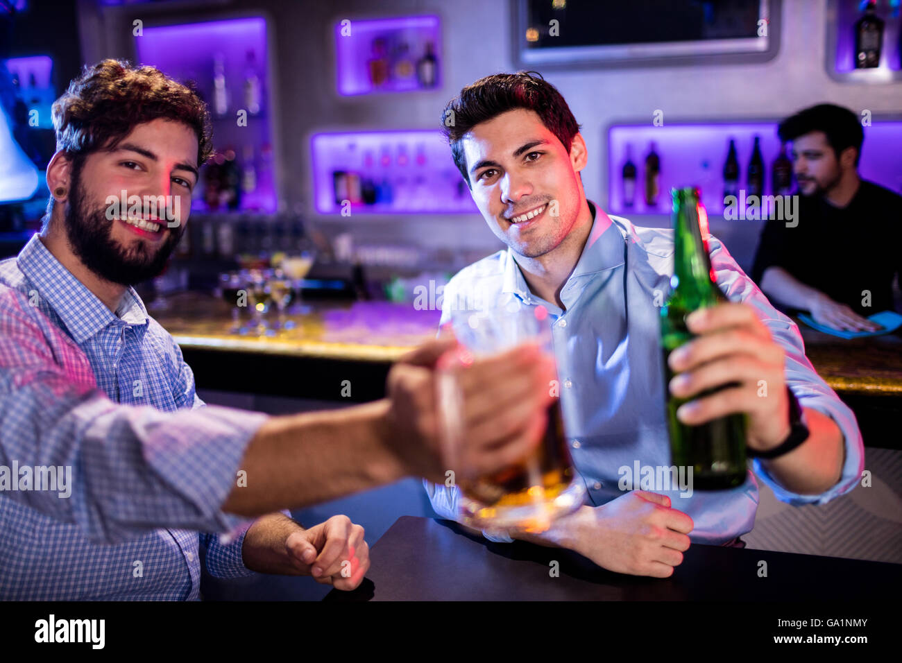 Portrait des hommes montrant verre de bière et une bouteille de bière Banque D'Images