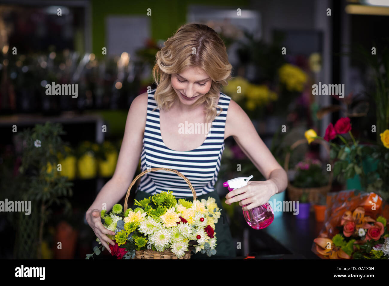 Les fleuristes, pulvériser de l'eau sur les fleurs dans le magasin de fleurs Banque D'Images