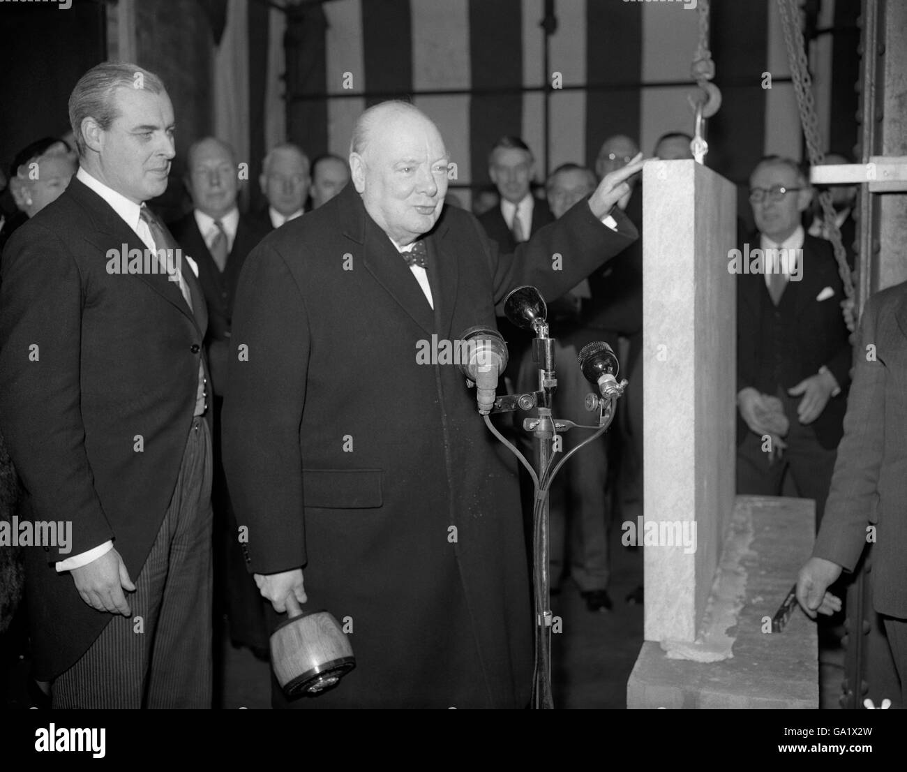 Le premier ministre, Sir Winston Churchill, a posé aujourd'hui (mercredi) la pierre angulaire du nouveau bâtiment de la Baltique à Londres, la Bourse étant fermée pour la journée. Plus tard, le premier ministre a été amusé à déjeuner sur le sol.après la cérémonie de pose de pierres, Sir Winston a déclaré que la pierre était bien et vraiment posée et l'homme qui a fait la pose de briques son hobby devrait savoir! Banque D'Images