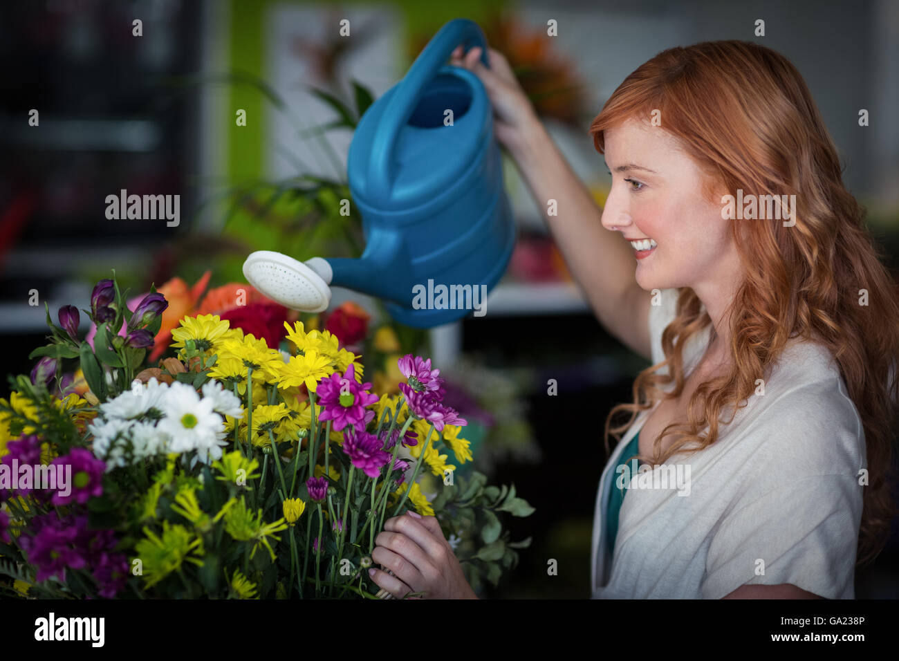 Female florist watering flowers Banque D'Images