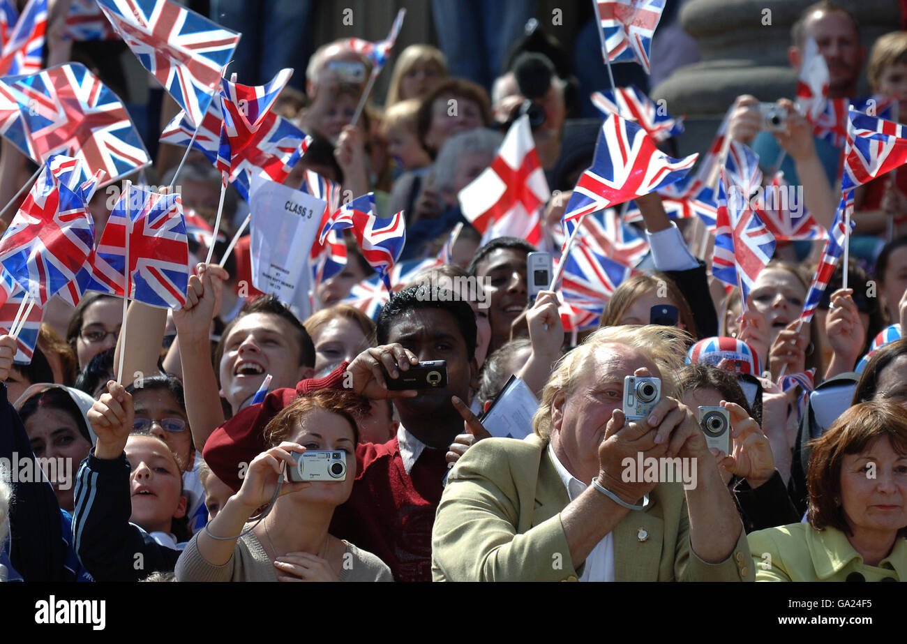 Les foules branle les drapeaux de l'Union tandis que la reine Elizabeth II visite Huddersfield en mai 2007. Banque D'Images