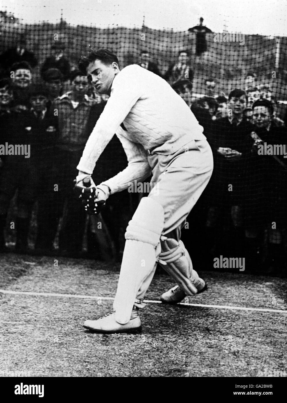 Keith Miller, Nouvelle-Galles du Sud et Australie, battant dans les filets, sous la surveillance de centaines de lycéens Banque D'Images