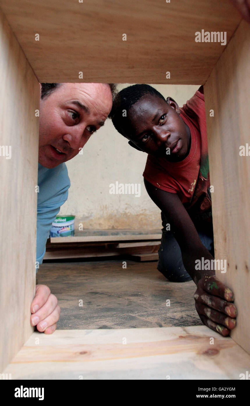 Brooks Newmark, député de Braintree, et un jeune garçon du projet Girubuntu, qui est une école et un orphelinat dans la ville de Kigali, Rwanda, des étagères de construction. Banque D'Images