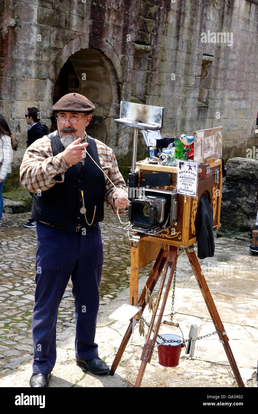 Un photographe de rue à Santillana del Mar a beaucoup d'affaires de touristes se rendant sur l'ancien village. Banque D'Images