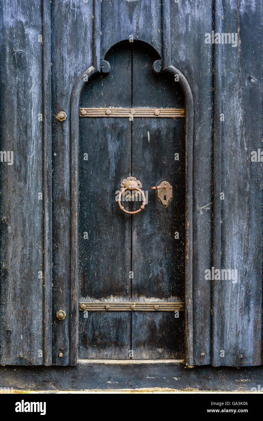Très vieille porte en bois noir avec poignée et serrure de fer rouillé. Banque D'Images