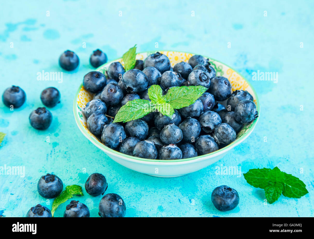 Les bleuets frais sain dans un bol avec les feuilles de menthe Banque D'Images