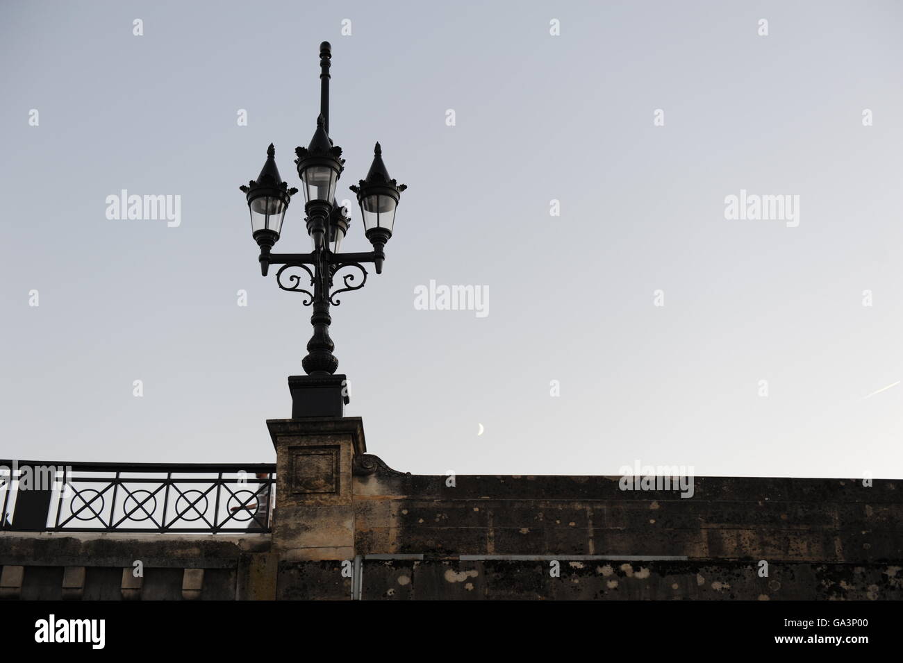 Une vieille rue de la lumière sur le pont de pierre (Bordeaux) et la Lune se levant dans le ciel. Banque D'Images