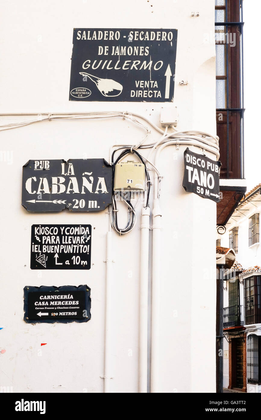 Vieilles enseignes encombré sur mur blanc au village espagnol, Grazalema, Andalousie, espagne. Banque D'Images