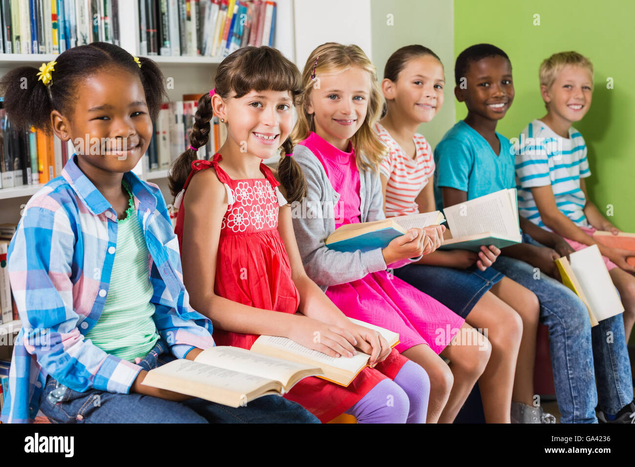 Portrait d'enfants reading book in library Banque D'Images