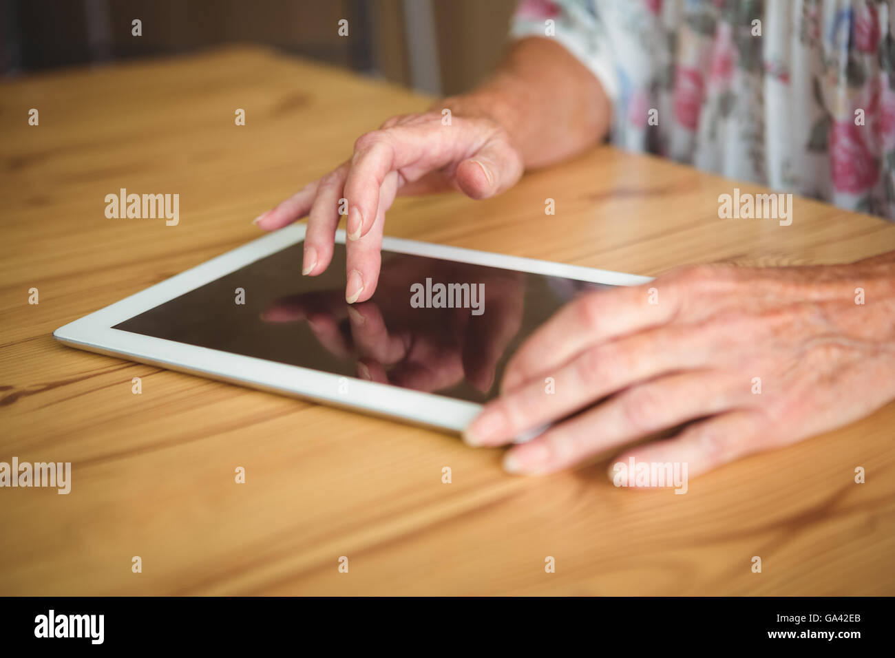 Vieille personne touchant une tablette numérique Banque D'Images