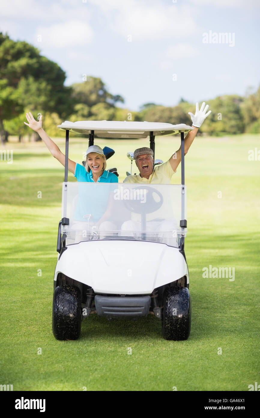 Cheerful couple sitting in golfeur voiturette de golf Banque D'Images