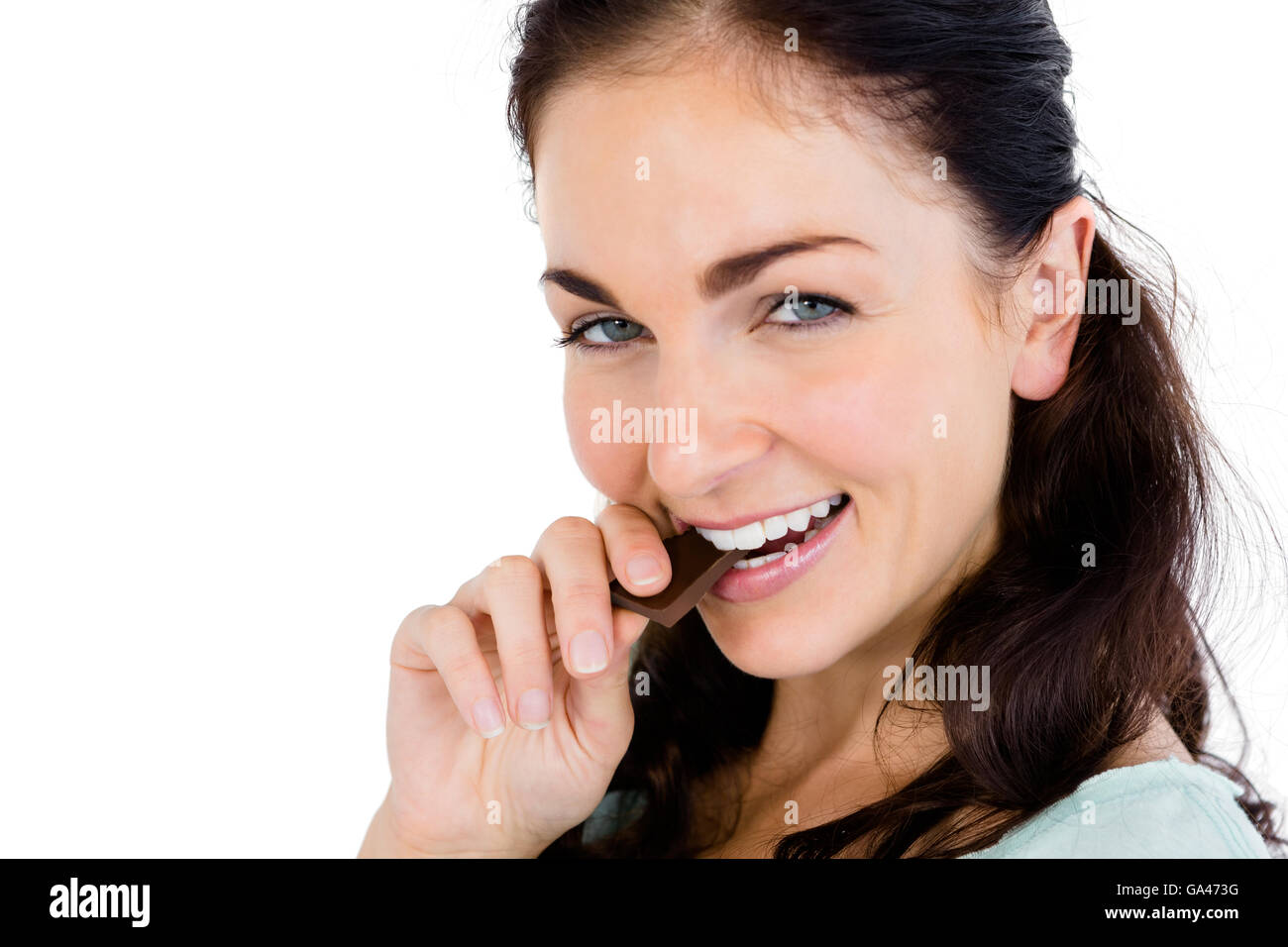 Close-up portrait of smiling woman eating chocolate bar Banque D'Images
