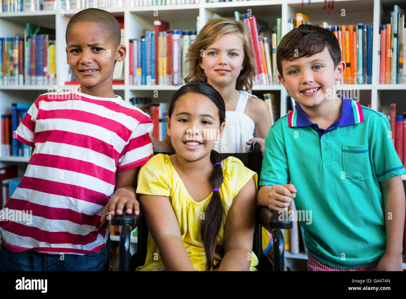 Fille handicapée avec des amis de bibliothèque à l'école Banque D'Images