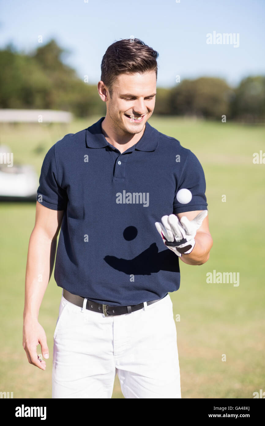 Cheerful Young man with golf ball Banque D'Images