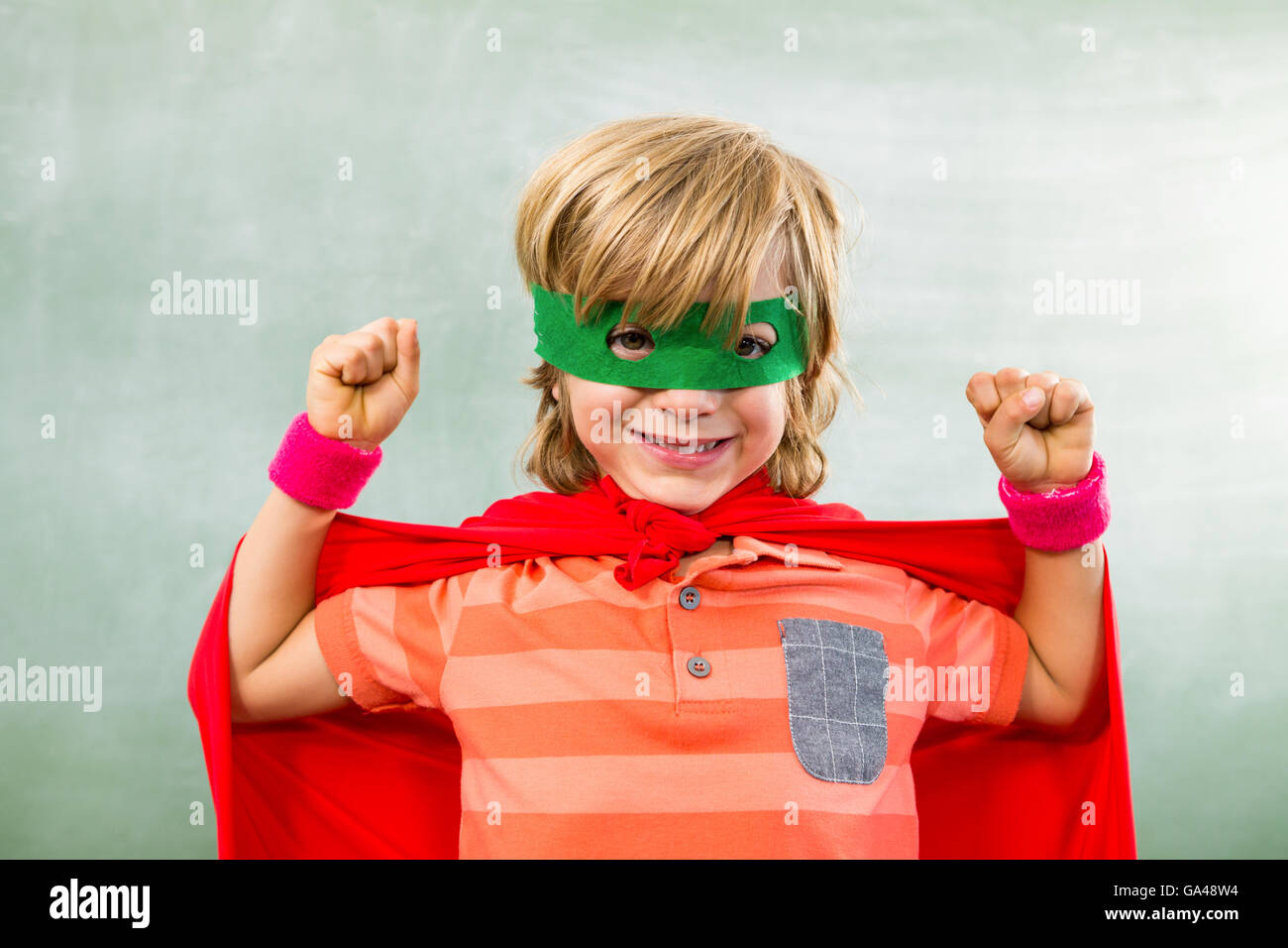 Heureux garçon habillé en super héros en classe Banque D'Images