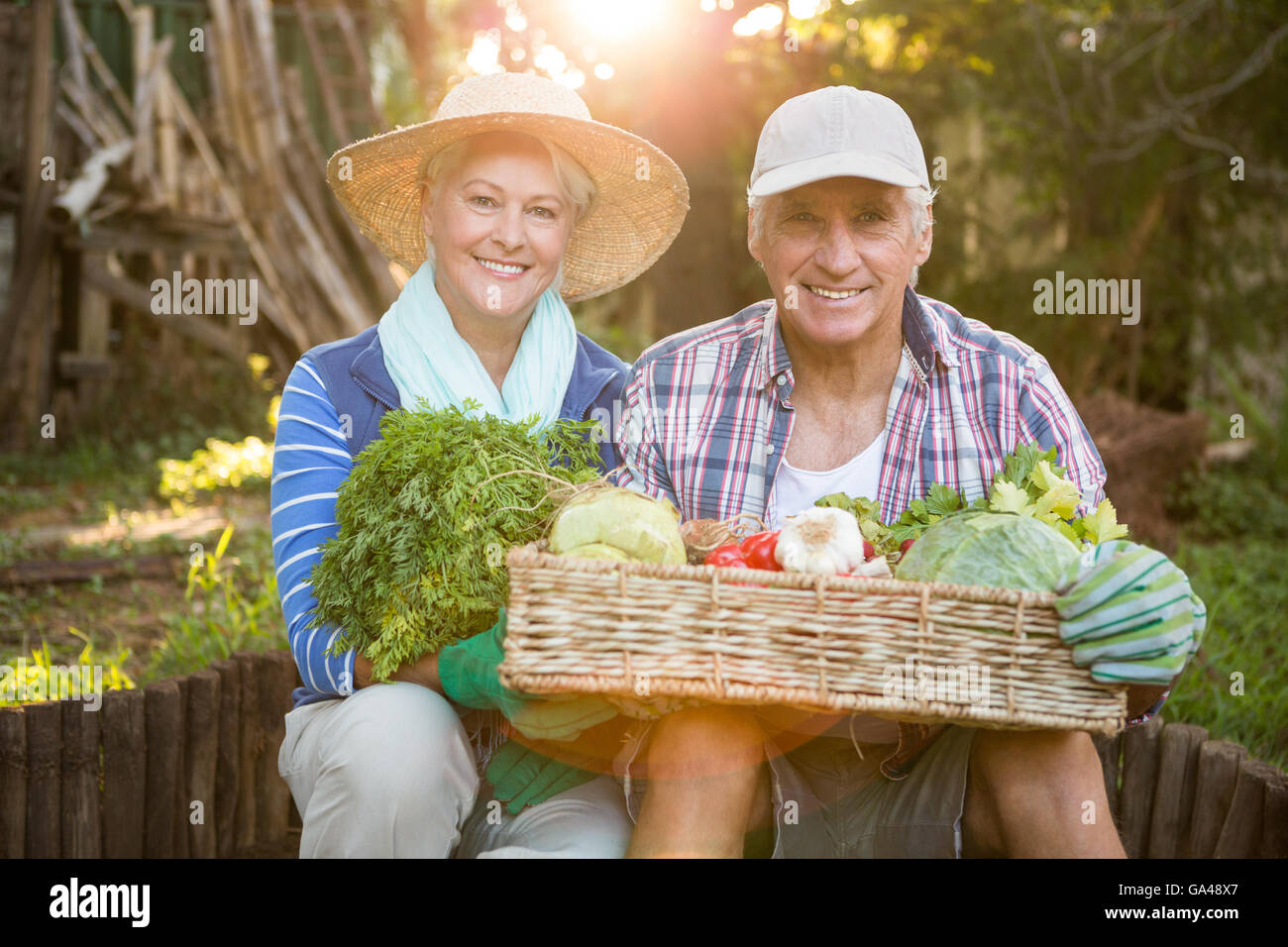 Portrait of mature couple transportant des légumes du jardin à la caisse Banque D'Images