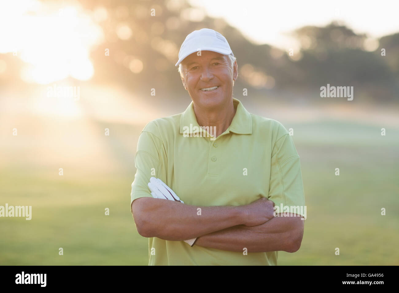 Portrait of smiling golfer with arms crossed Banque D'Images