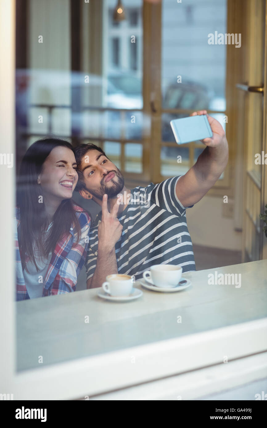 Cheerful couple en tenant à selfies cafétéria Banque D'Images