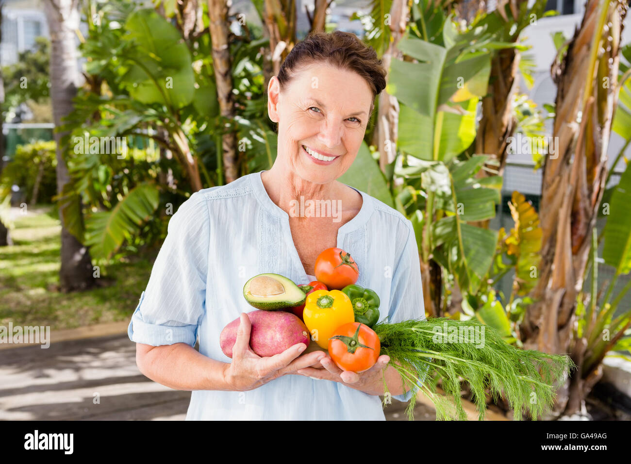 Cheerful woman holding fruits et légumes Banque D'Images