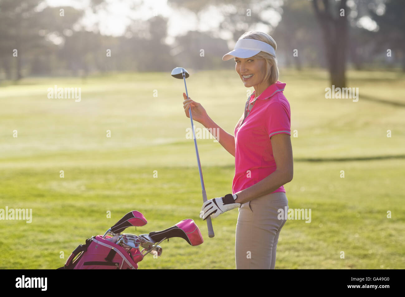 Portrait of young woman carrying golf club Banque D'Images